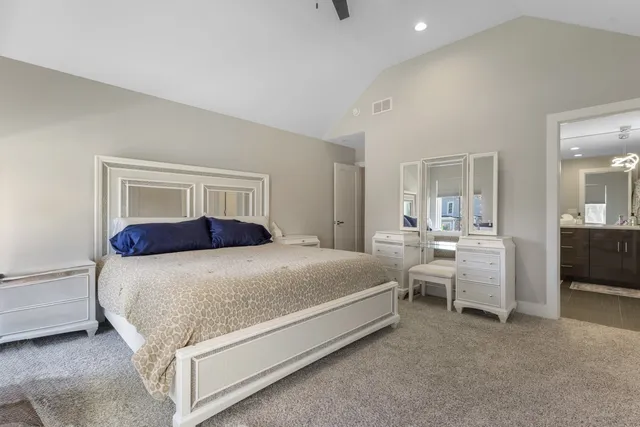a bedroom with bed and white cabinets