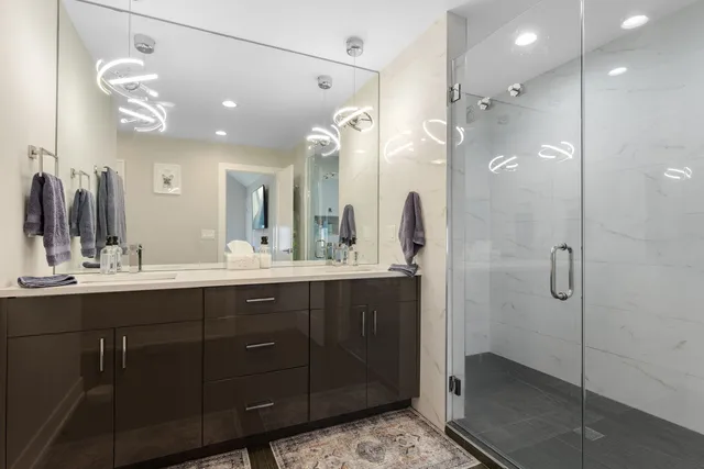 a bathroom with a double vanity sink mirror and shower