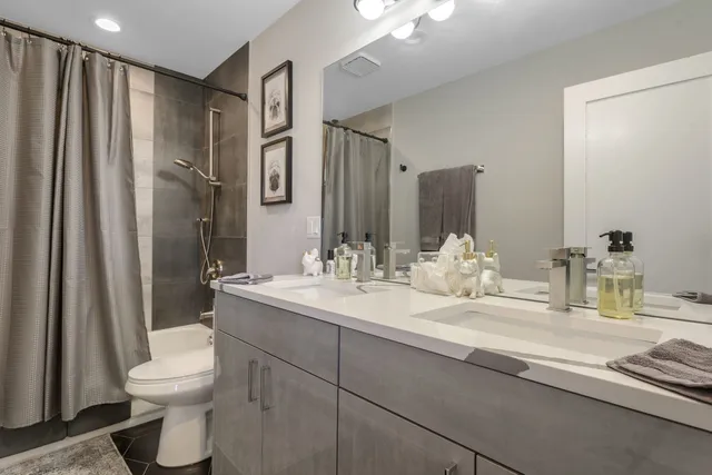 a bathroom with a double vanity sink toilet and a mirror