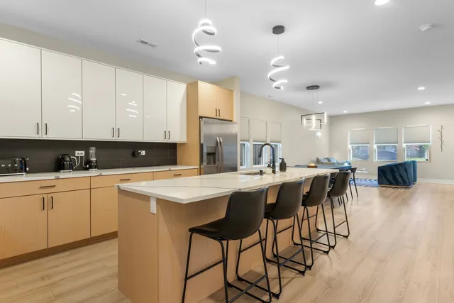 a kitchen with stainless steel appliances granite countertop a table chairs sink and cabinets