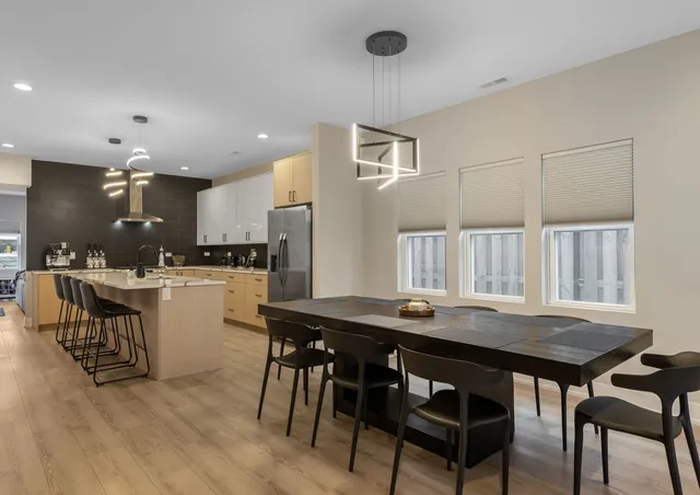 a kitchen with a table chairs a sink dishwasher window and cabinets
