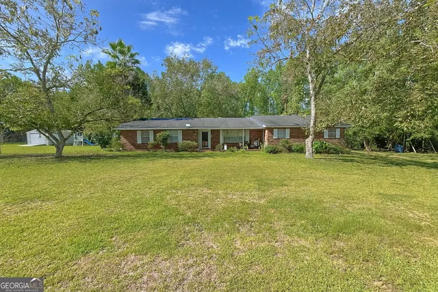 a view of a house with yard and sitting area