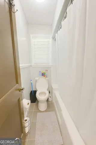 a white toilet sitting next to a bathroom sink and a window