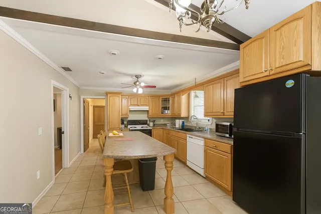 a kitchen with a sink a refrigerator and cabinets
