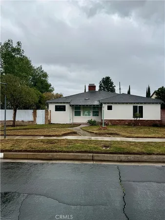 a view of a big house with a big yard and large trees