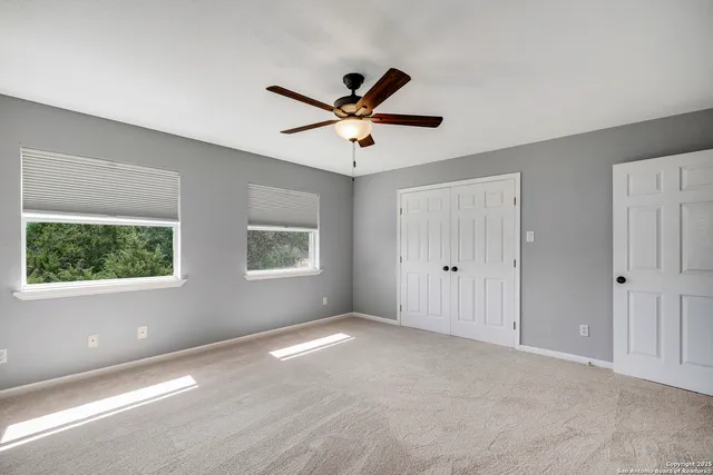 a view of a livingroom with a ceiling fan and window