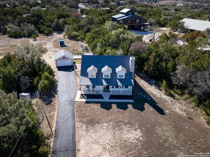 an aerial view of a house with a yard and lake view