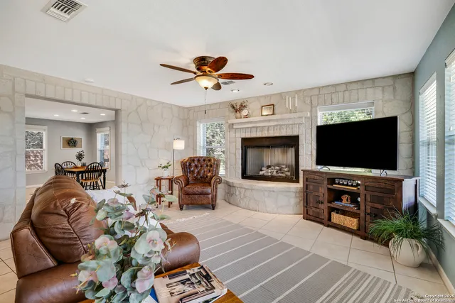 a living room with furniture a flat screen tv and a fireplace