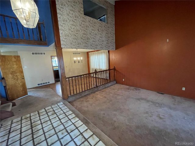 a view of a livingroom with wooden floor and stairs