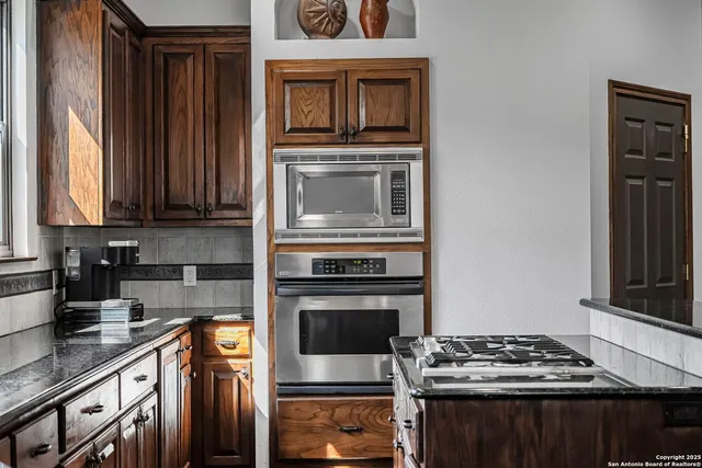 a kitchen with stainless steel appliances a stove and a microwave