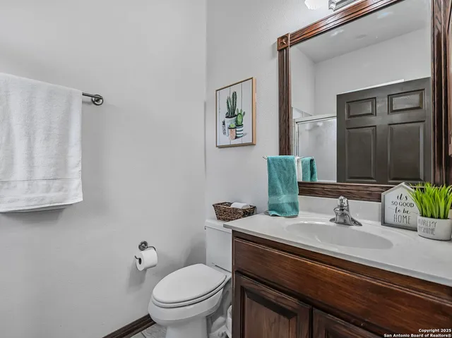 a bathroom with a granite countertop toilet sink and mirror