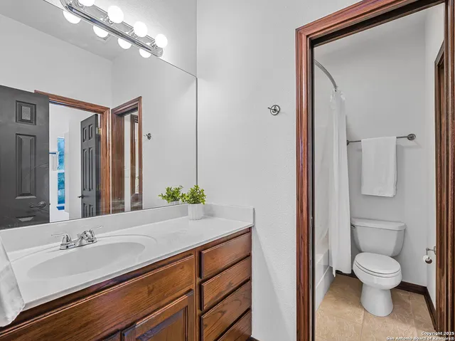 a bathroom with a granite countertop sink mirror and toilet