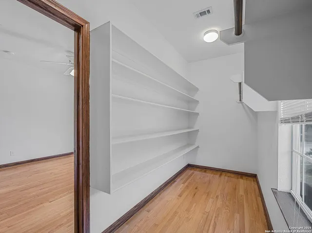 a view of walk in closet with empty racks