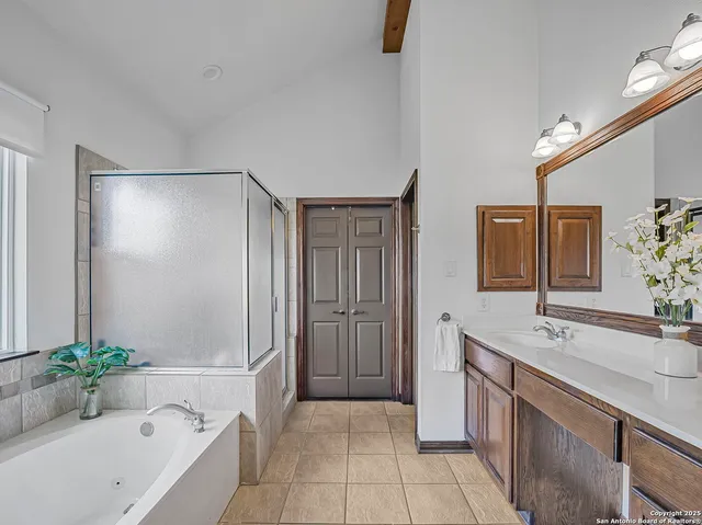 a bathroom with a tub sink and mirror