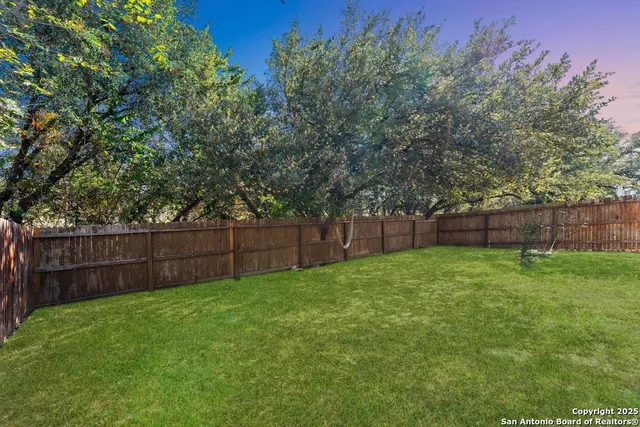 a view of backyard with wooden fence