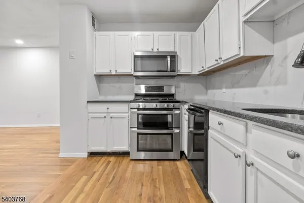 a kitchen with granite countertop a stove and a microwave
