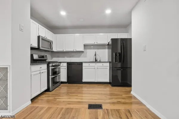 a kitchen with stainless steel appliances granite countertop a refrigerator stove and a sink