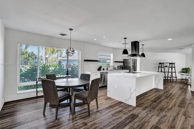 a kitchen with a dining table chairs and white cabinets
