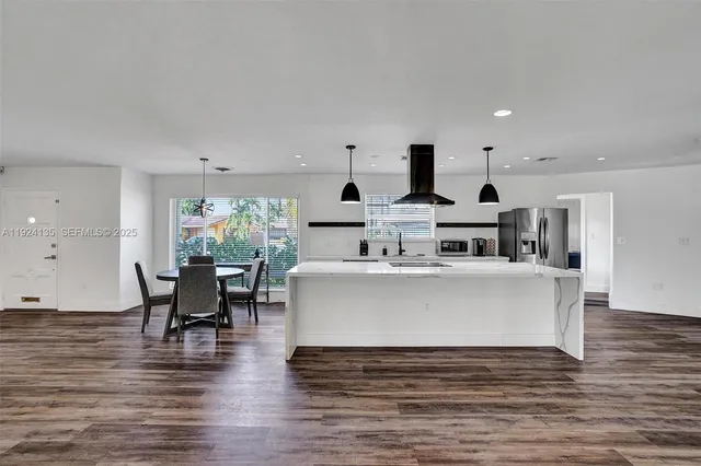 a living room with furniture a wooden floor and a sink