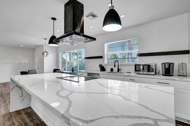 a kitchen with stainless steel appliances granite countertop a sink a stove and cabinets