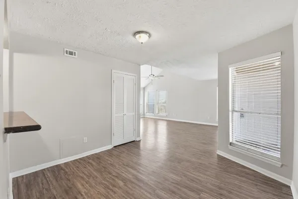 a view of an empty room with wooden floor
