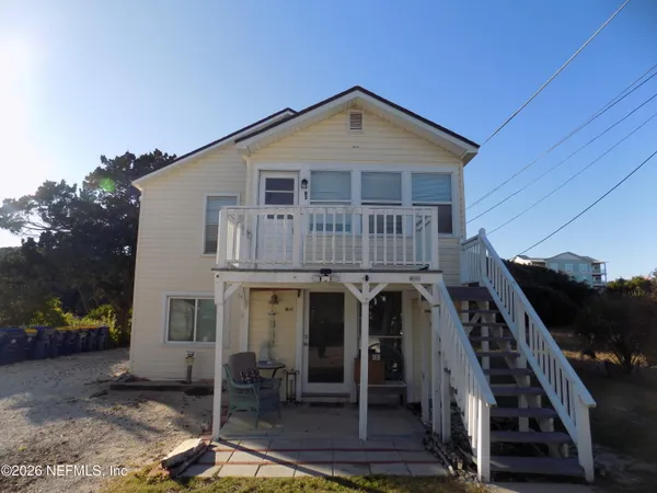 a view of a house with wooden deck and furniture