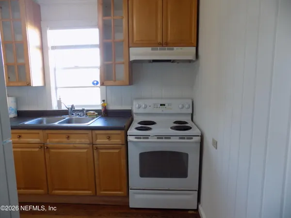a kitchen with granite countertop cabinets stainless steel appliances and a sink