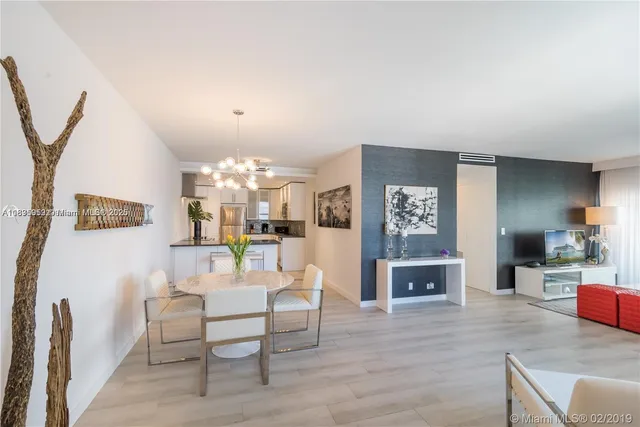 a living room with furniture a fireplace and a chandelier