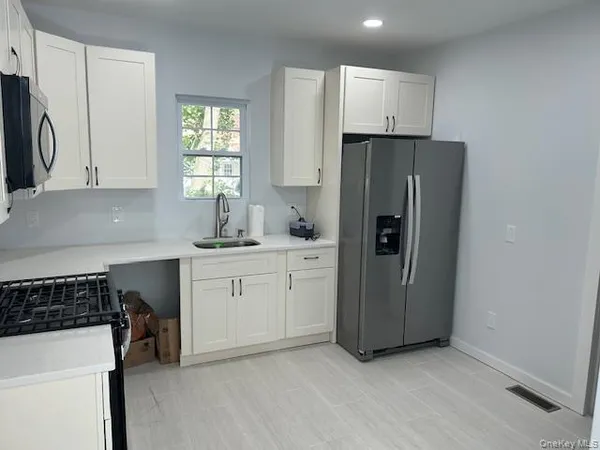 a kitchen with a refrigerator sink and cabinets