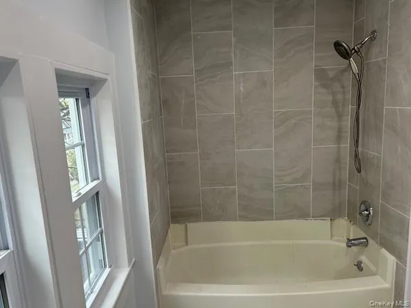 a white bath tub sitting next to a shower