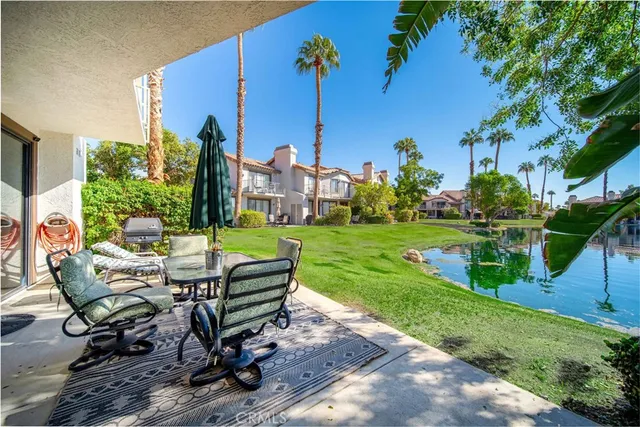 a view of a patio with table and chairs potted plants and palm tree