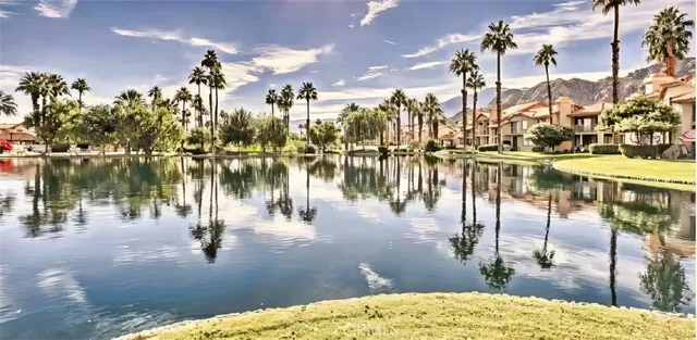 a view of a brick house with potted plants next to a road