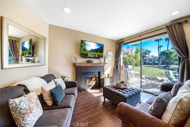 a living room with furniture a fireplace and a floor to ceiling window