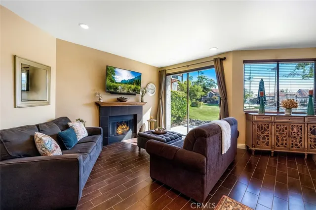 a living room with fireplace furniture and a large window