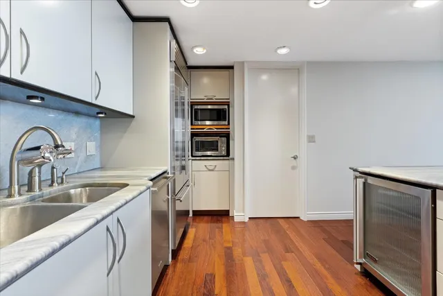 a view of a kitchen with a sink and dishwasher wooden floor