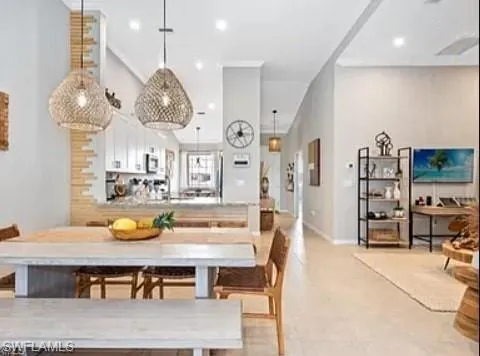 a living room with furniture a chandelier and kitchen view