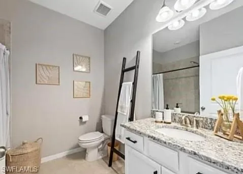 a bathroom with a granite countertop toilet sink and mirror