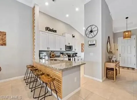 a kitchen with stainless steel appliances kitchen island granite countertop a table and chairs in it