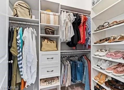9397 Pocida Court, Unit 203 Naples, FL 34119 - Photo 30 of 32 a view of walk in closet with clothes and shoes