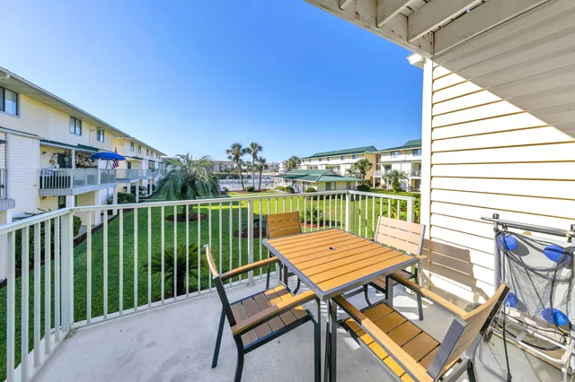 a view of a patio with a table and chairs and floor to ceiling window with wooden floor