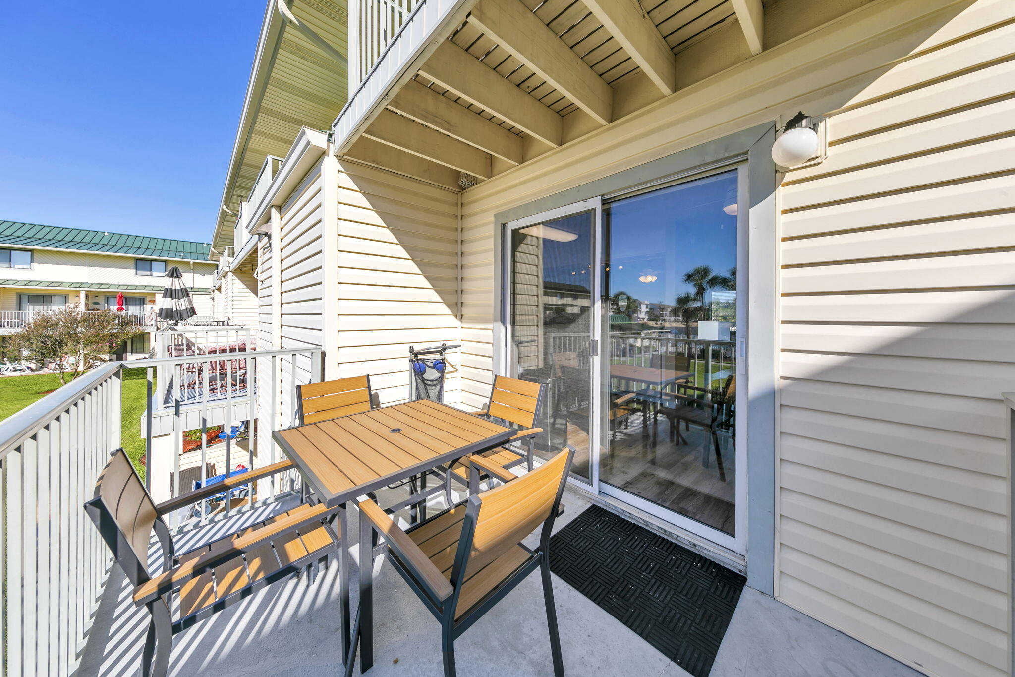 60 Sandprints Drive, Unit C12 Miramar Beach, FL 32550 - Photo 21 of 53 a view of a patio with a table and chairs and floor to ceiling window with wooden floor