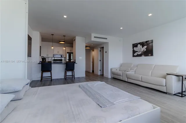 a living room with furniture and a dining table with kitchen view
