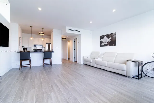 a living room with furniture and a kitchen view