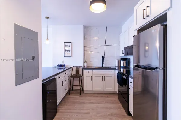 a kitchen with stainless steel appliances granite countertop a refrigerator a stove and a sink