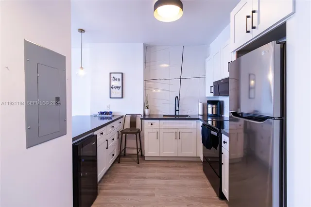 a kitchen with stainless steel appliances granite countertop a refrigerator a stove and a sink