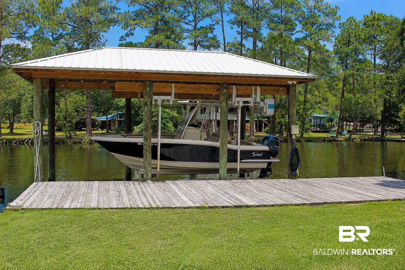 9825 Wolf Creek Ridge Elberta, AL 36530 - Photo 65 of 76 Waterfront property featuring a covered boat lift, wood decking, and a manicured lawn