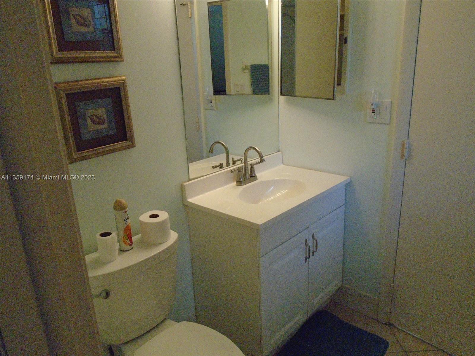 Sabal Palm of Pine Davie, FL 33324 - Photo 13 of 30 a bathroom with a sink toilet and mirror
