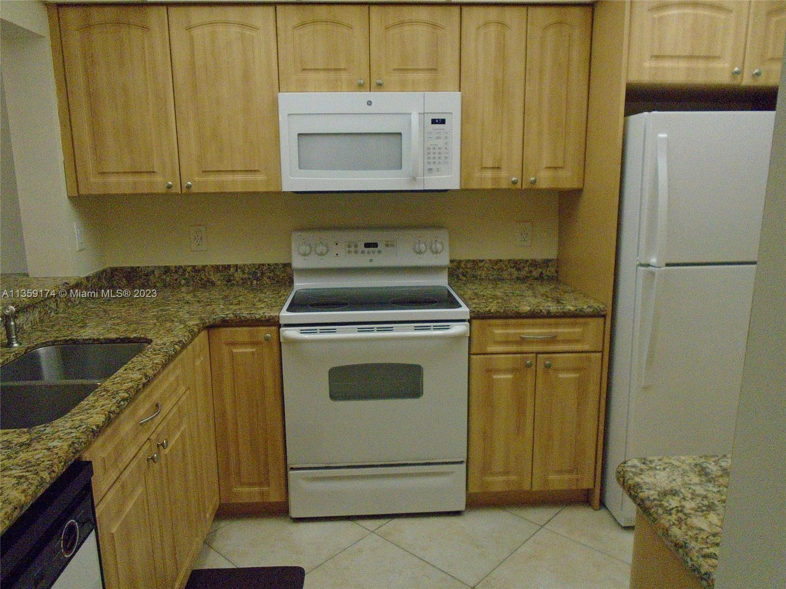 Sabal Palm of Pine Davie, FL 33324 - Photo 8 of 30 a kitchen with granite countertop cabinets stainless steel appliances and a sink