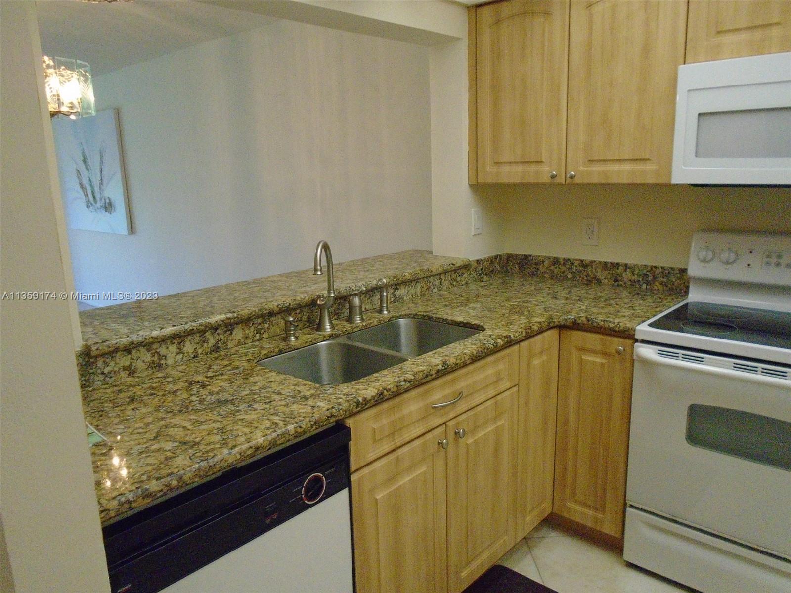 Sabal Palm of Pine Davie, FL 33324 - Photo 9 of 30 a kitchen with granite countertop a sink and a stove