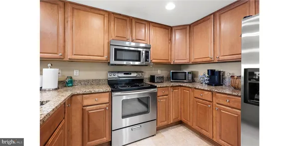 a kitchen with stainless steel appliances granite countertop a sink a stove a microwave and cabinets